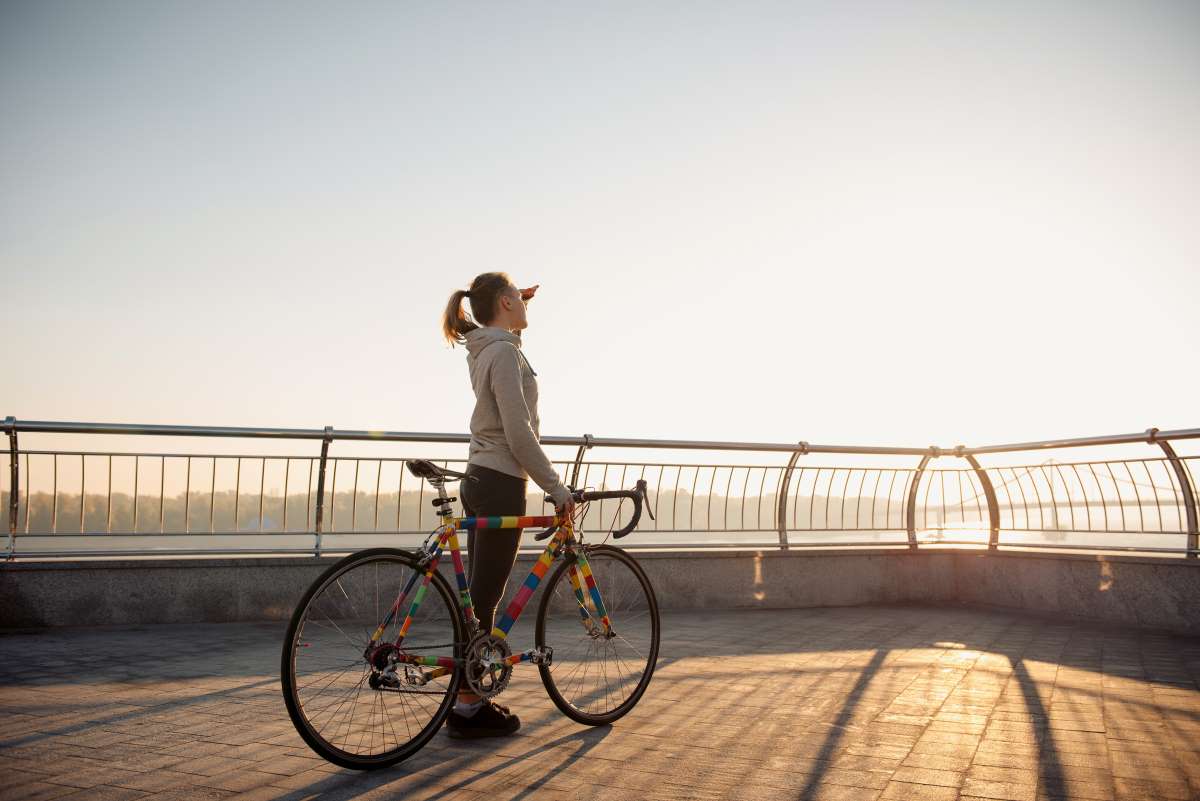 Young woman riding a bicycle in the city at sunrise