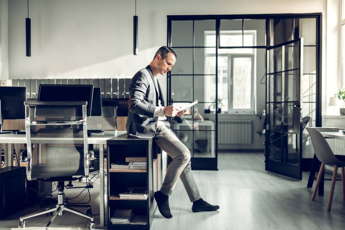 Stylish prosperous businessman reading documents 