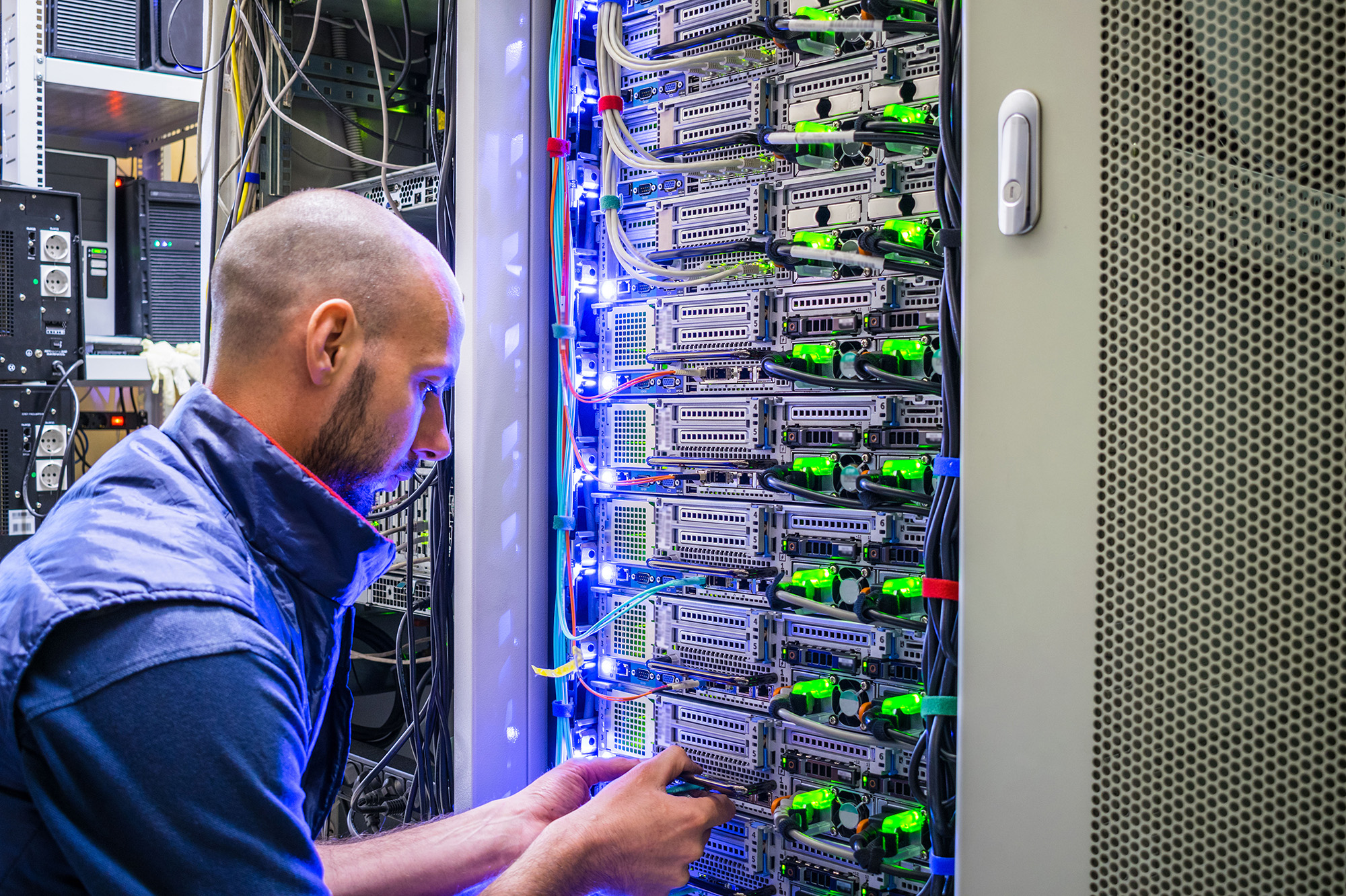A Specialist Connects The Wires In A Server Room A Specialist Connects The Wires In A Server Room