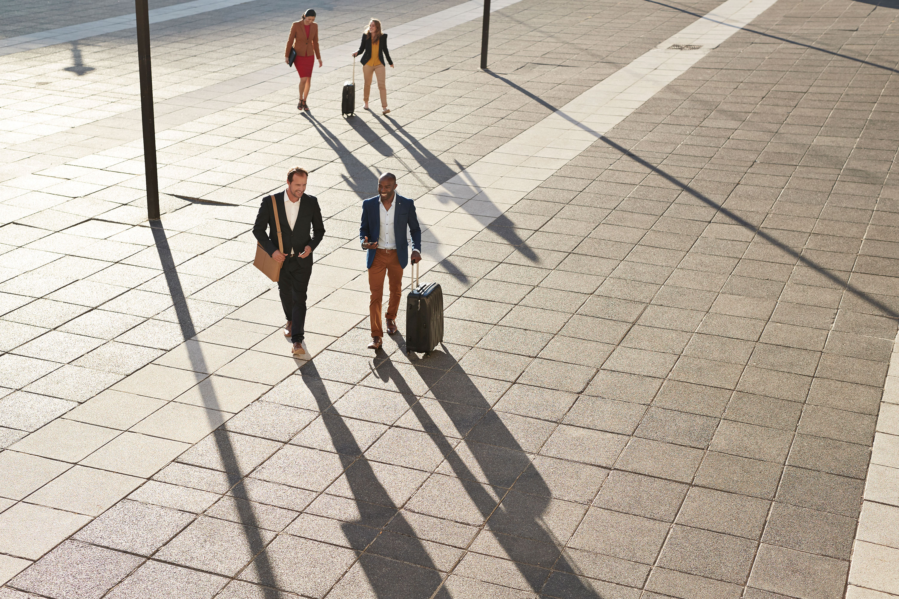 Businesspeople_Walking_Across_Square_With_Suitcases