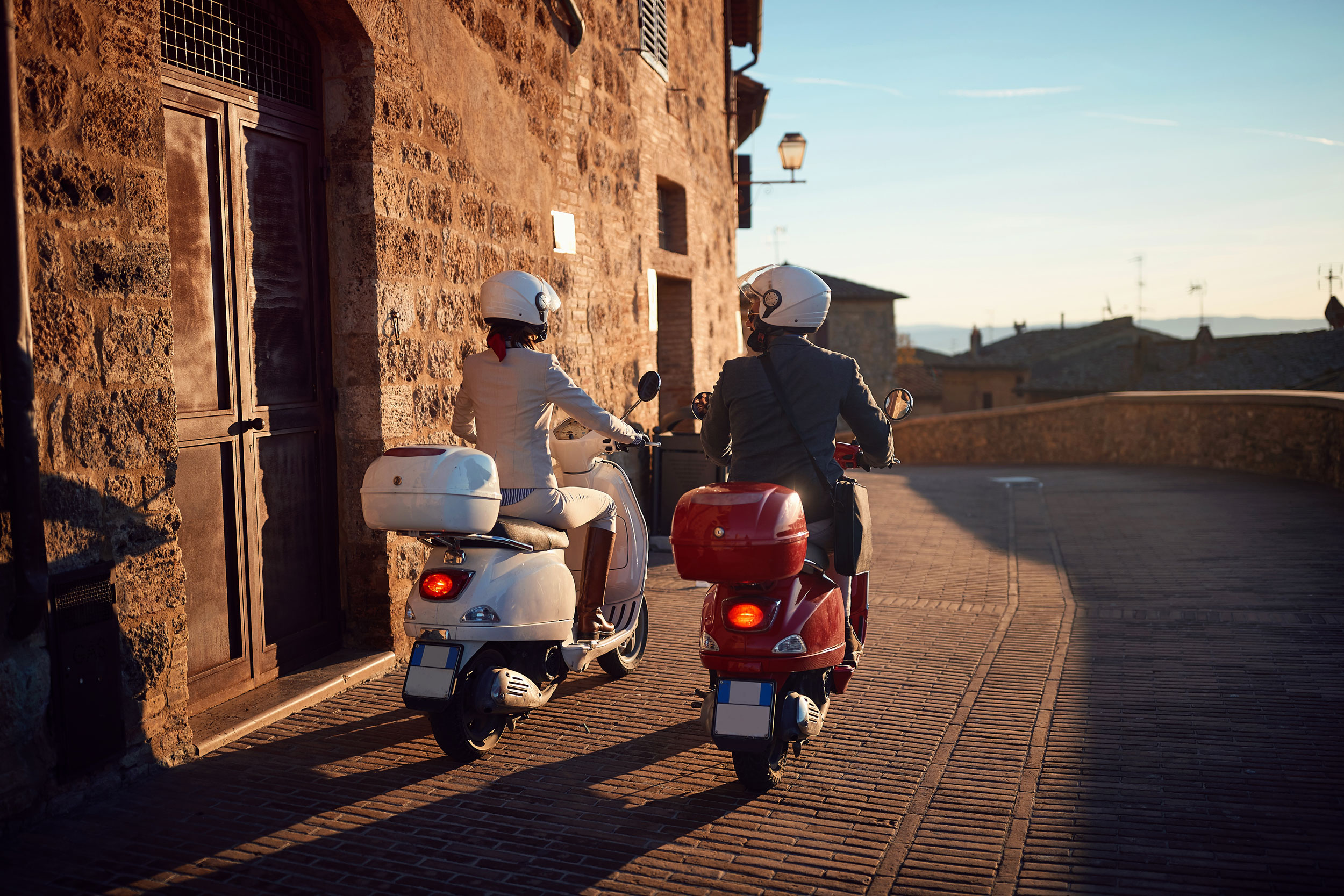 Man And Woman On Vespa Scooters Man And Woman On Vespa Scooters