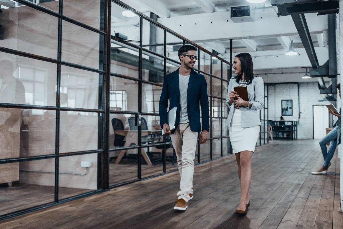 Happy business partners walking through office